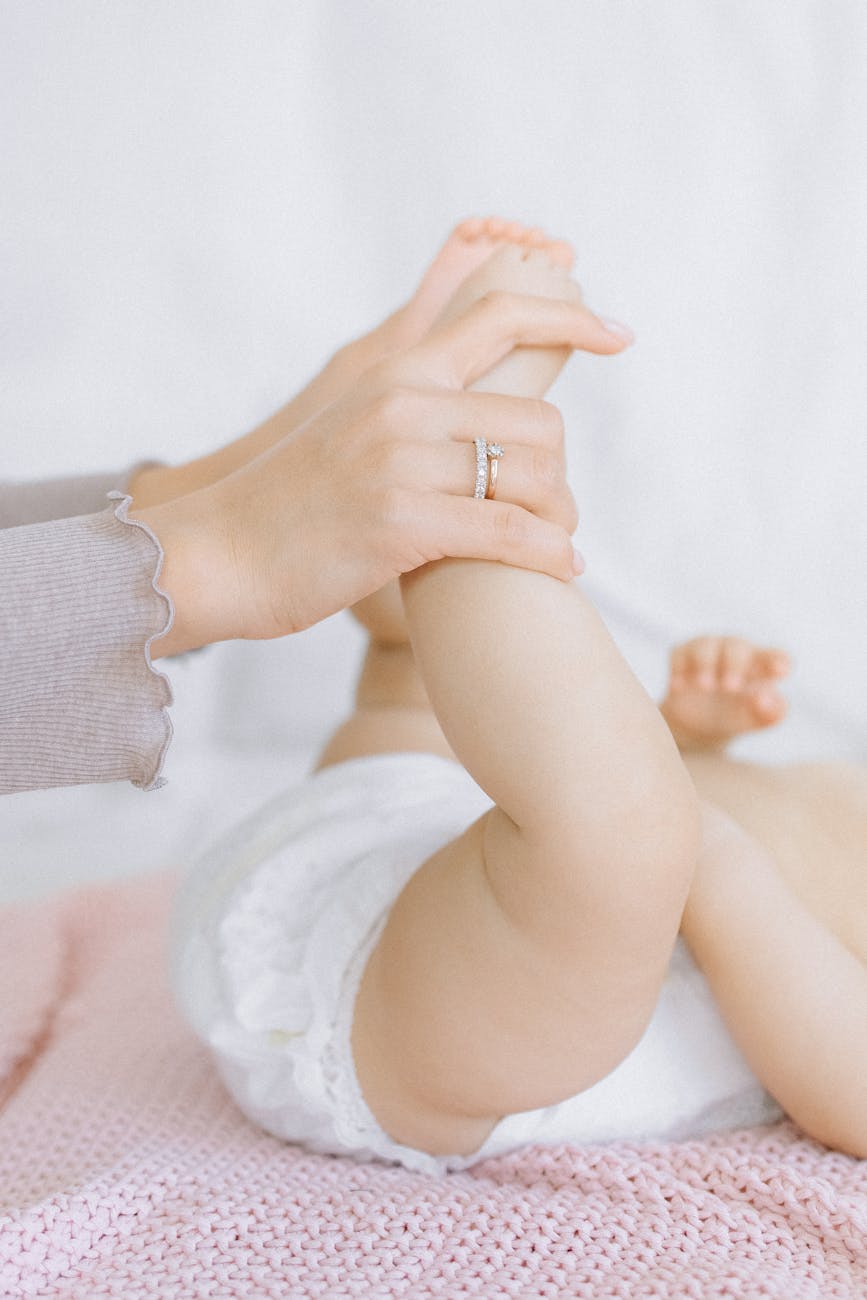 a person holding the legs of a baby