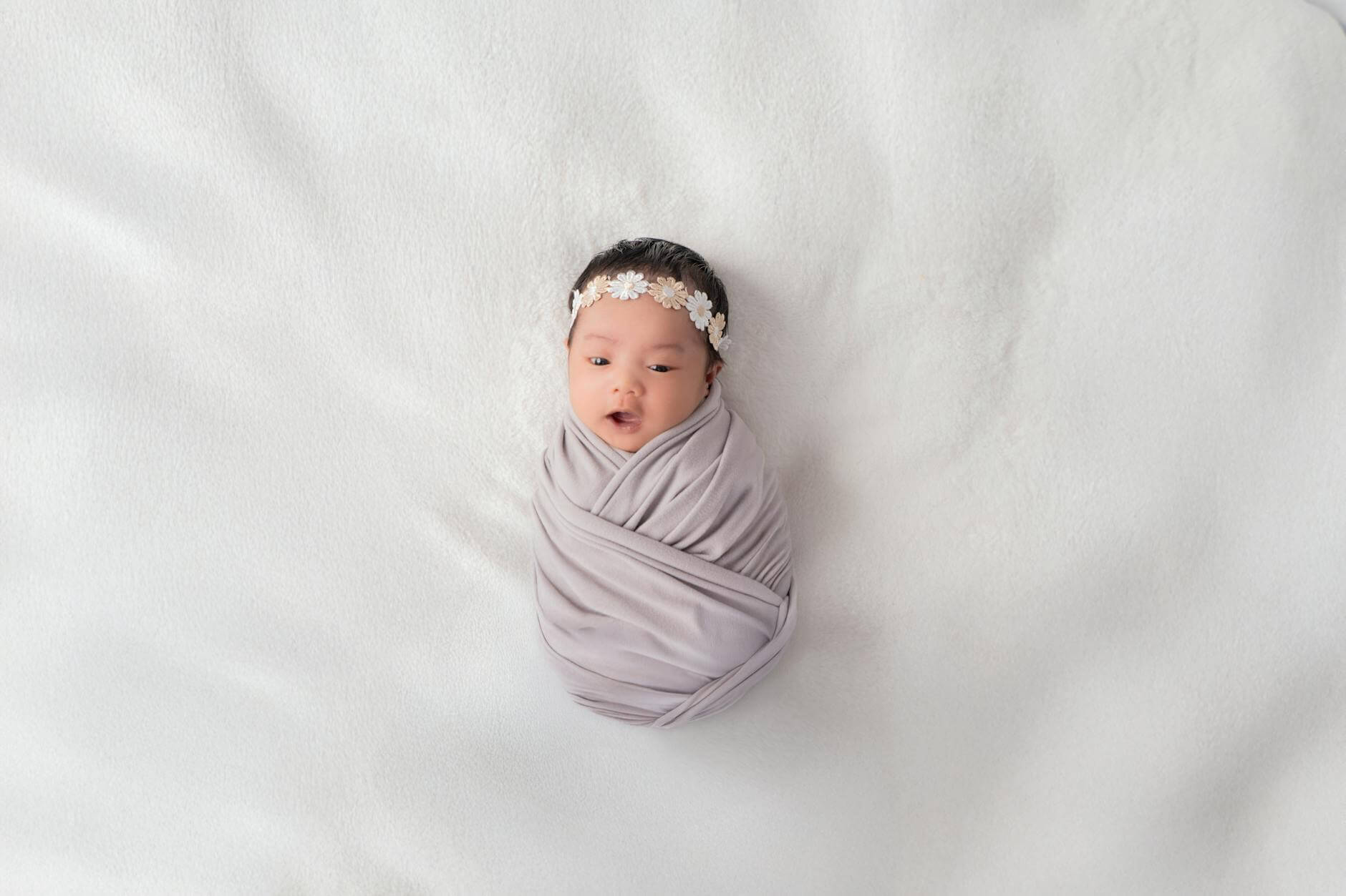 adorable baby wrapped in white blanket