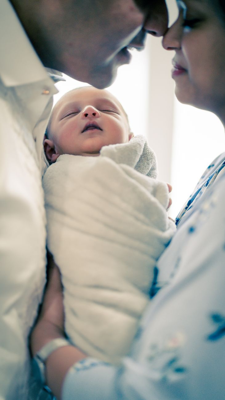 romantic couple with newborn baby in daytime