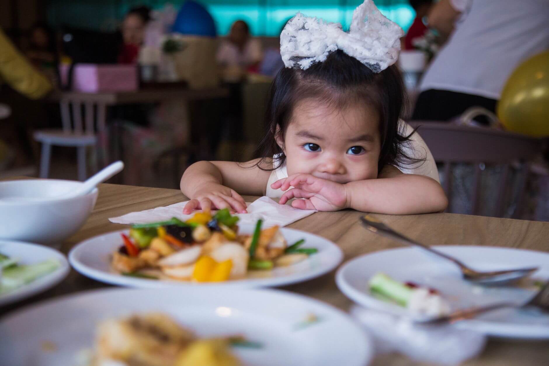 selective focus photo of a cute kid in a restaurant