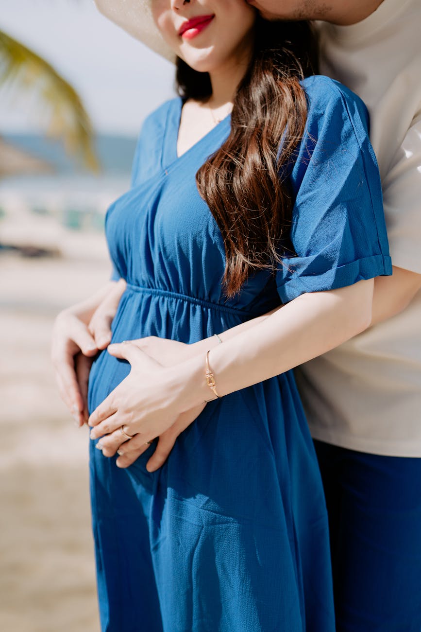 man and woman in blue dress holding her tummy