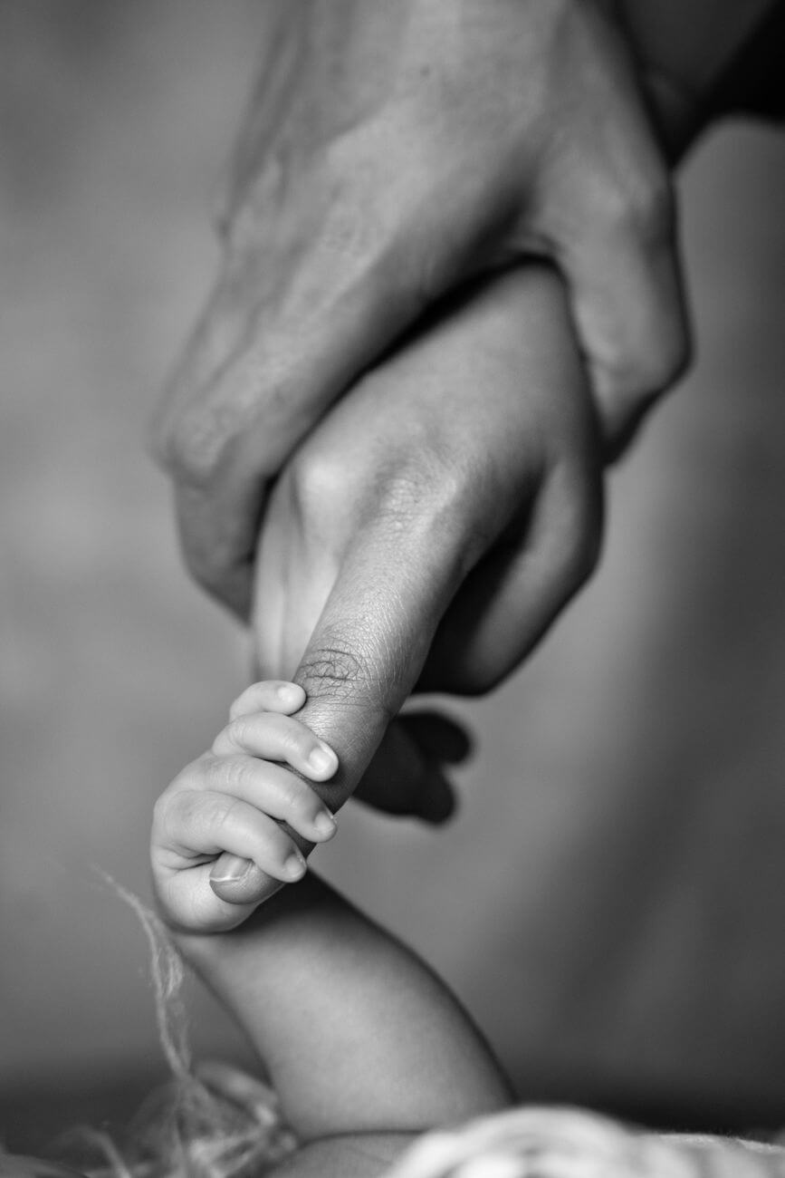 baby holding mother finger