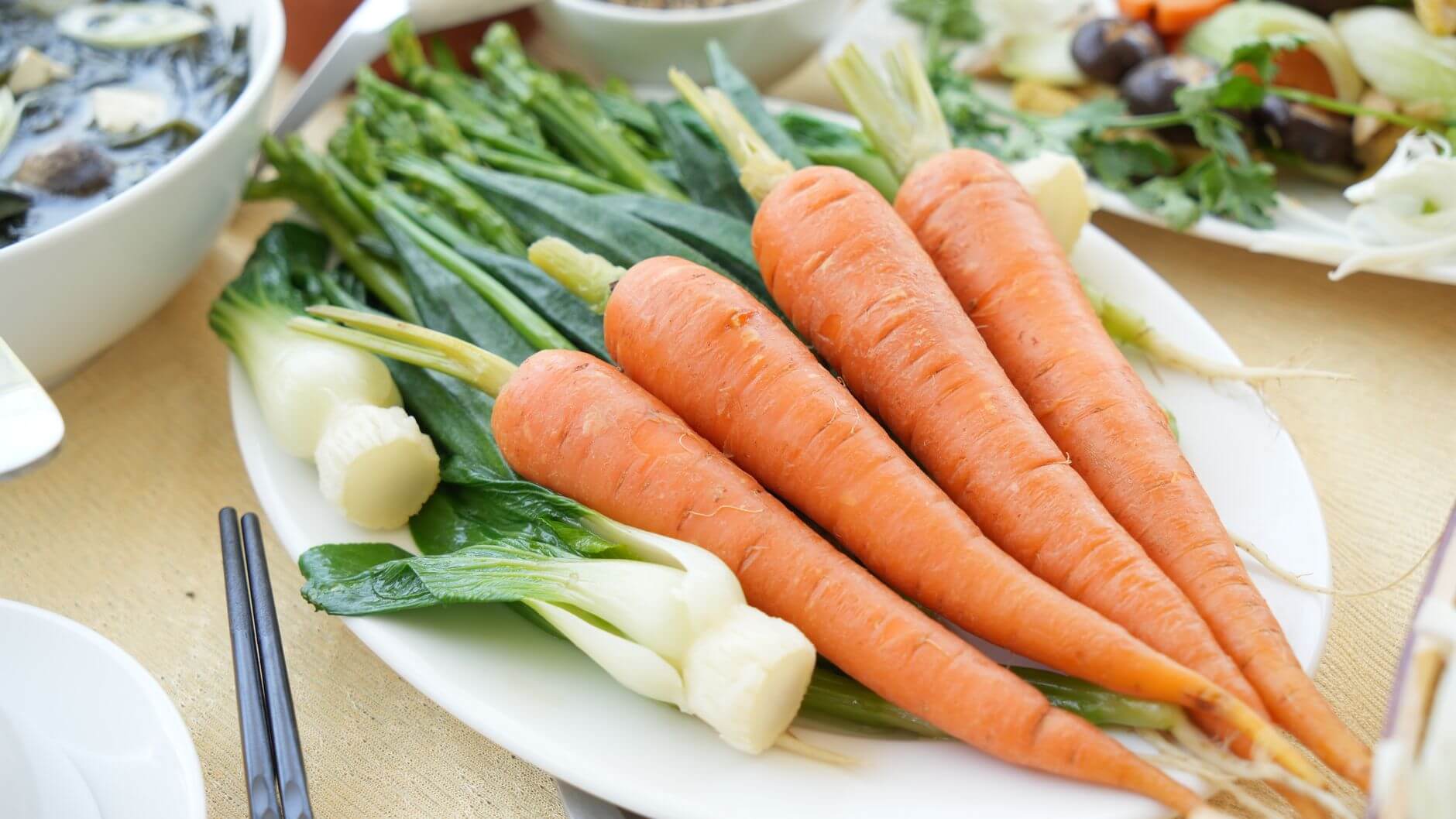 fresh carrots and green vegetables on a plate