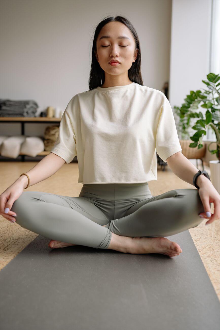 person sitting on yoga mat while meditating